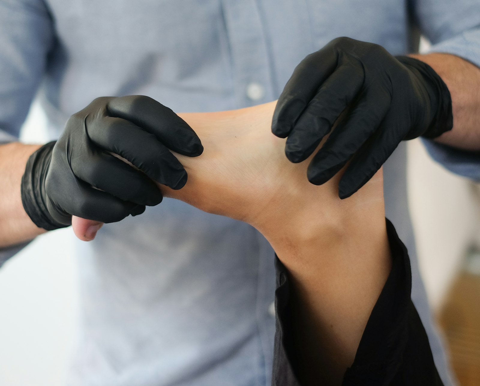 Podólogo con guantes evaluando el pie de un paciente para tratar un uñero